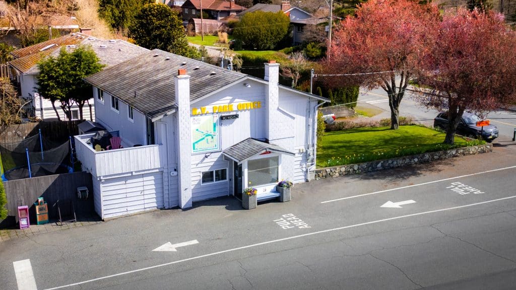 Front entrance of Fort Victoria RV Park office building with sign and parking area.