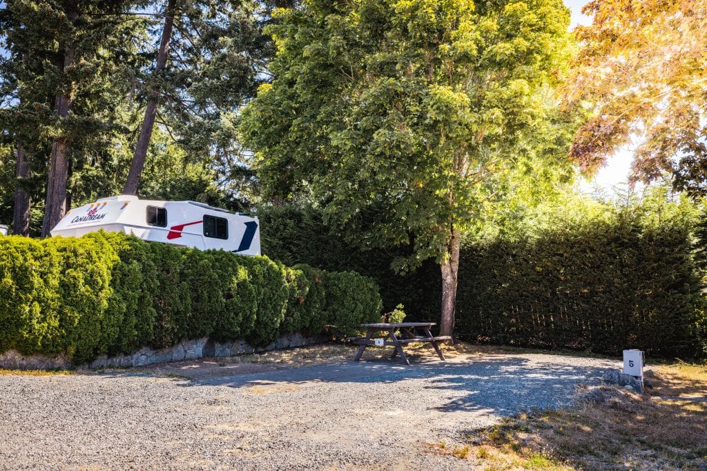 Shaded RV parking spot with surrounding trees at Fort Victoria RV Campground