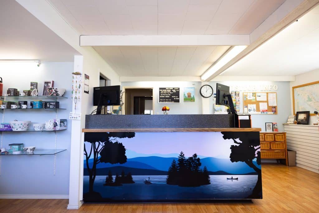 Front desk and reception area at Fort Victoria RV Park office with scenic mural and visitor information displays