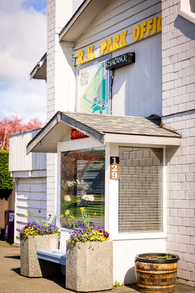 Color photo of Fort Victoria RV Park Office entrance decorated with flowers.